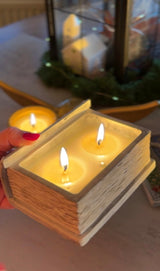 Lit Enchanted Book Candle with three cotton wicks and glowing soy wax