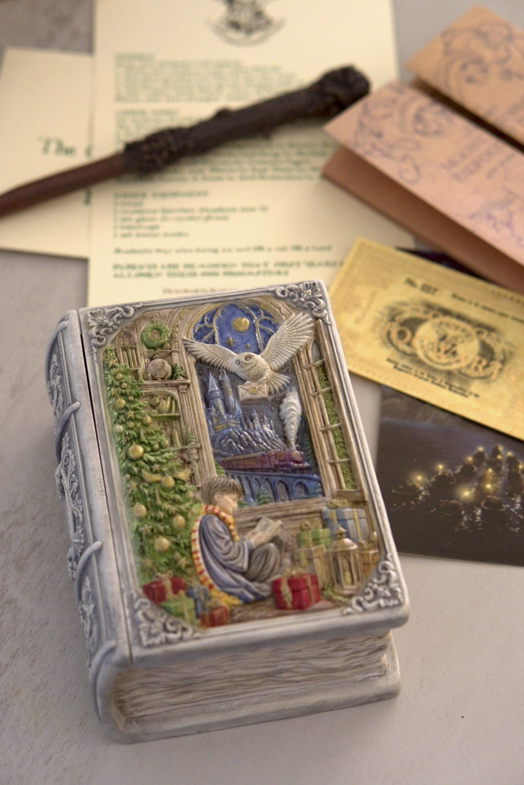 Enchanted Book Candle displayed with a wand, old papers and fantasy decor