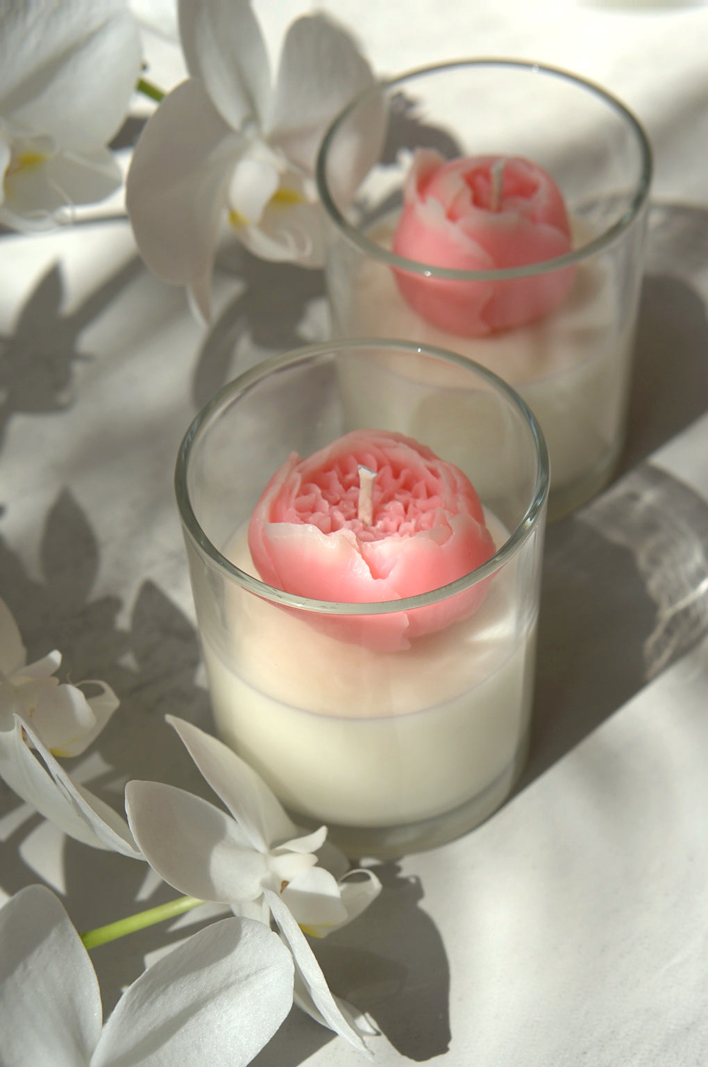 Close-up of a pink 3D peony soy candle in a clear glass jar