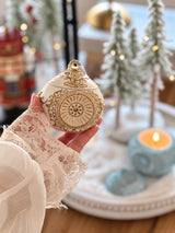 Ivory and gold Romanov Secret handmade candle held in hand, showing its size and ornate detail