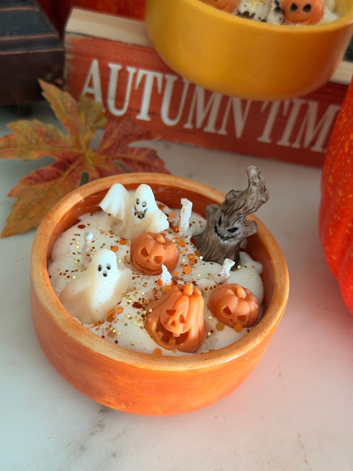 Close view of handmade Spooky Candle with ghost and jack-o'-lantern soy wax figures